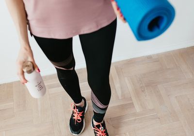 Close-up of a folded yoga mat and a water bottle.